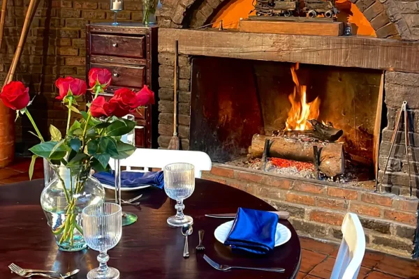 Mesa decorada con flores al lado de una chimenea